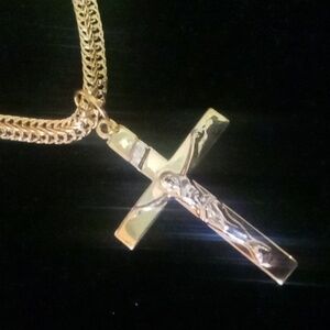 Flattened gold tone chain with a Jesus on a cross pendant necklace.